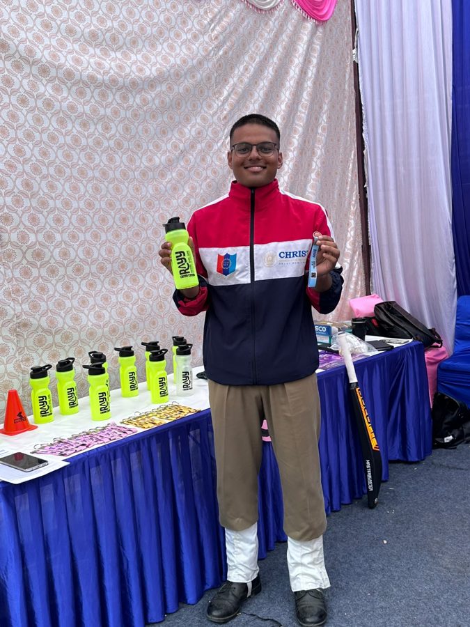 A visitor holding a RAYY bottle at the RAYY stall